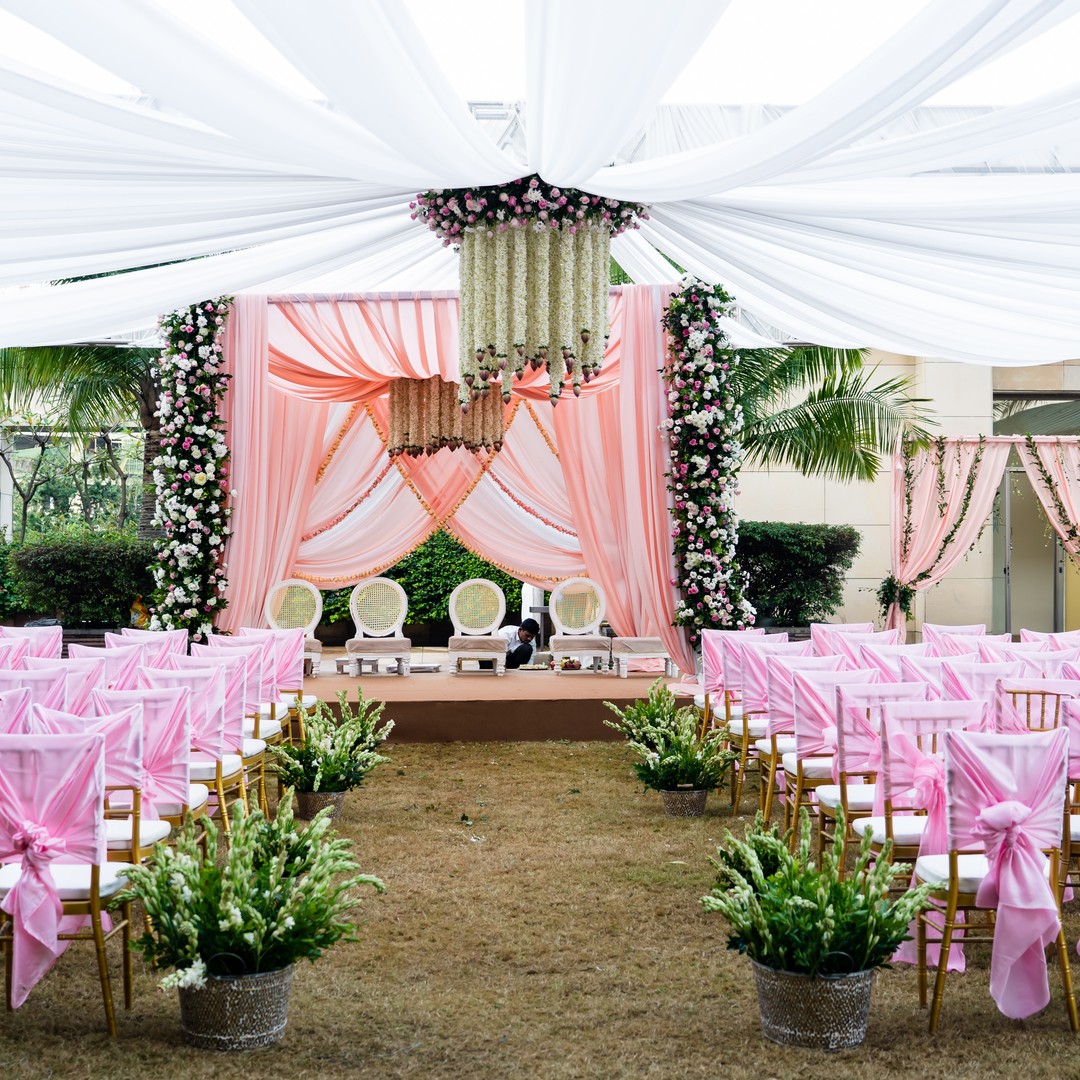 Pink floral aisle leading to a wedding mandap